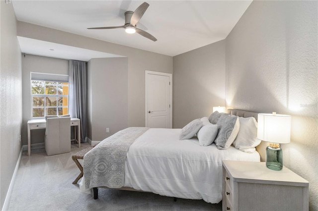 bedroom with light colored carpet, ceiling fan, and baseboards