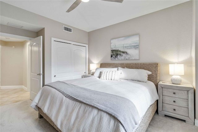 bedroom featuring a closet, visible vents, light carpet, ceiling fan, and baseboards