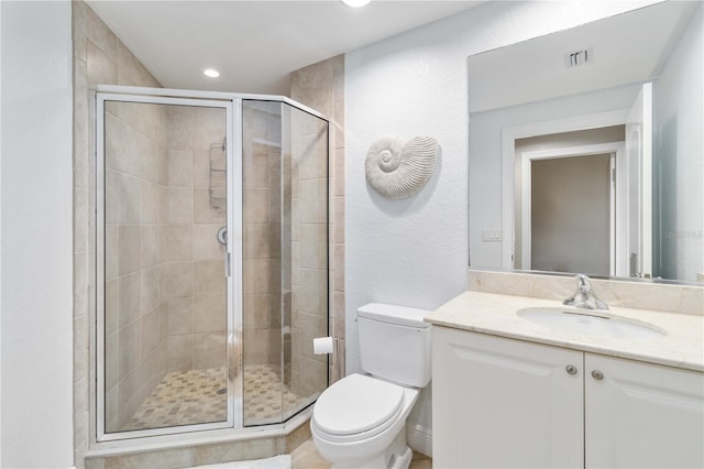 bathroom featuring toilet, a stall shower, vanity, and visible vents