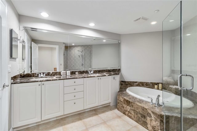 bathroom featuring double vanity, visible vents, a bath, a shower stall, and a sink