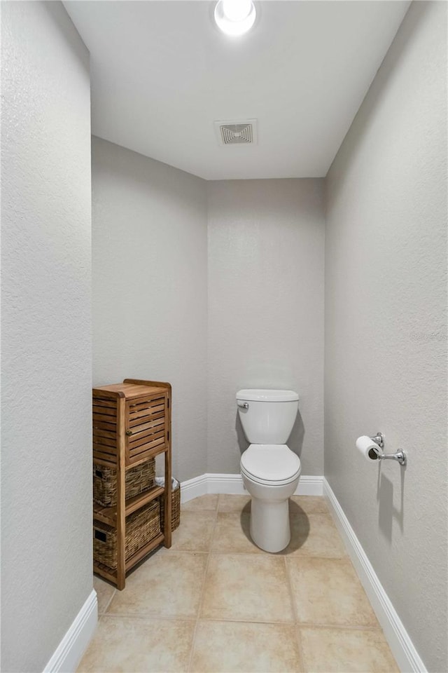 bathroom with toilet, baseboards, visible vents, and tile patterned flooring