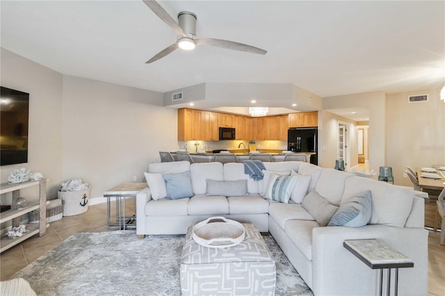 living area featuring baseboards, visible vents, a ceiling fan, and light tile patterned flooring