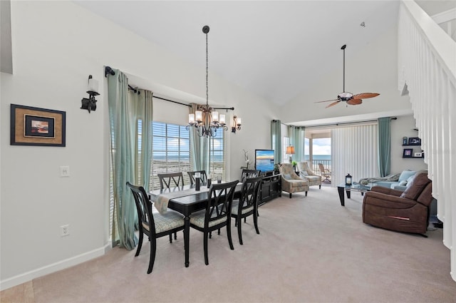 dining space featuring baseboards, ceiling fan with notable chandelier, high vaulted ceiling, and light colored carpet