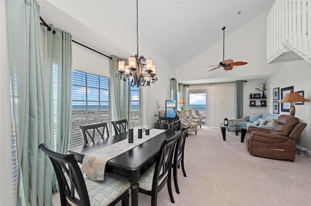 dining space with light carpet, high vaulted ceiling, and ceiling fan with notable chandelier