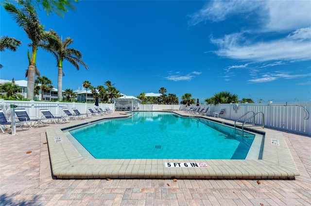 community pool featuring fence and a patio