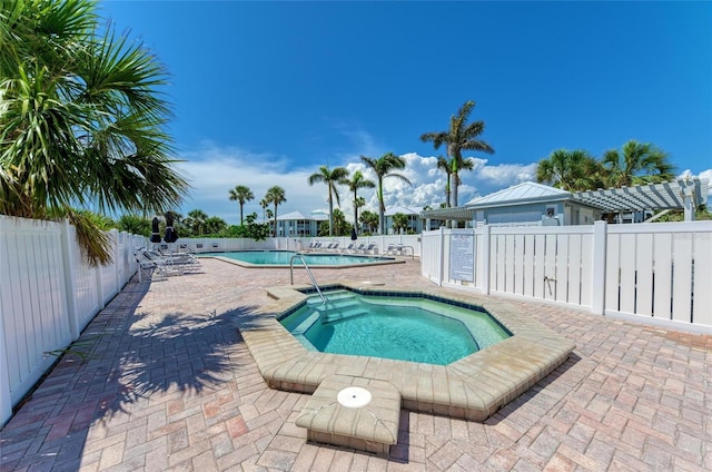 community pool featuring a fenced backyard and a hot tub