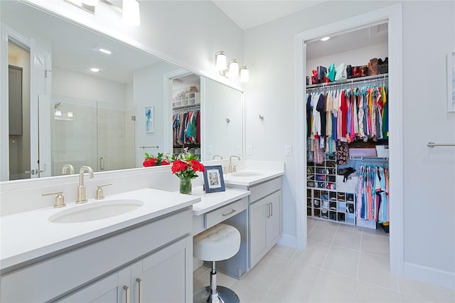 full bath featuring a spacious closet, a shower stall, vanity, and tile patterned floors