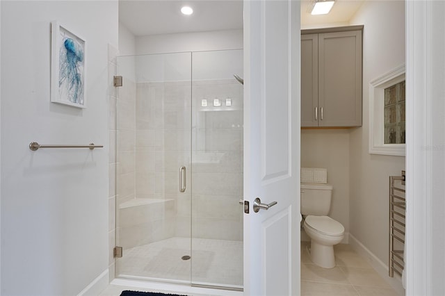 full bath with tile patterned flooring, baseboards, a shower stall, and toilet