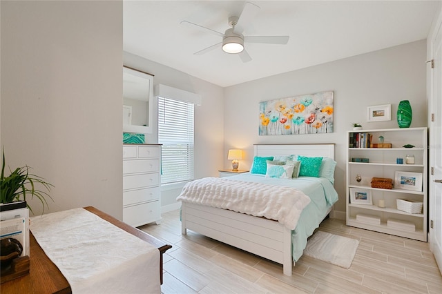 bedroom featuring ceiling fan, baseboards, and wood tiled floor