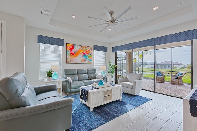 living room with visible vents, a tray ceiling, ceiling fan, and recessed lighting