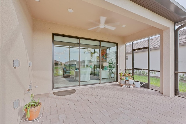 unfurnished sunroom with a ceiling fan