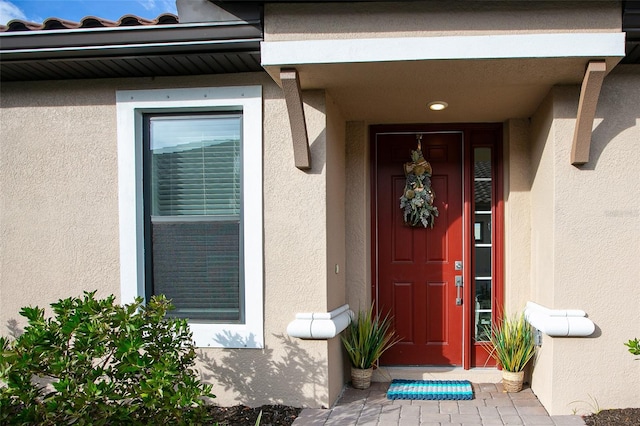 doorway to property featuring stucco siding