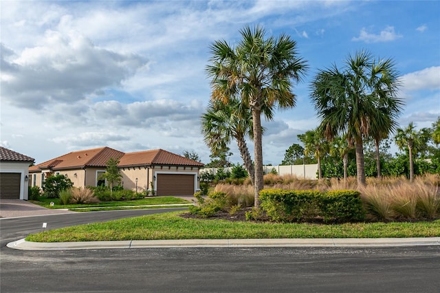 view of front of house with a garage, a tile roof, and stucco siding