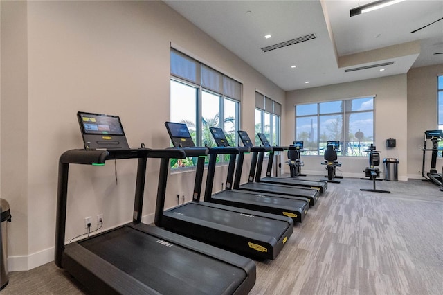 workout area featuring baseboards, visible vents, wood finished floors, and recessed lighting