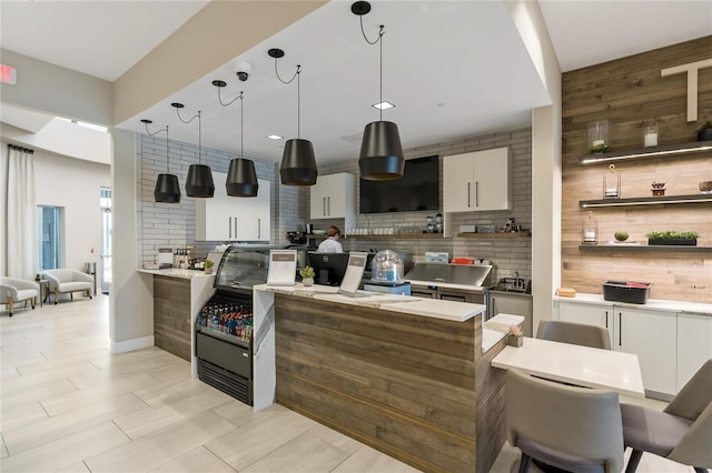 kitchen with light countertops, white cabinetry, hanging light fixtures, and open shelves