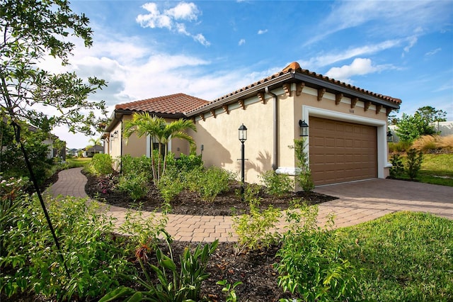 3008 Tolmino Ct, Lakewood Ranch, FL 34211 - view of home's exterior featuring stucco siding, decorative driveway, a tile roof, and a garage