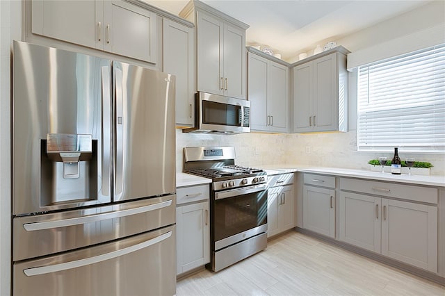 3008 Tolmino Ct, Lakewood Ranch, FL 34211 - kitchen with tasteful backsplash, gray cabinets, appliances with stainless steel finishes, and light countertops