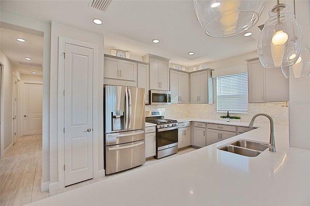3008 Tolmino Ct, Lakewood Ranch, FL 34211 - kitchen featuring a sink, gray cabinets, visible vents, backsplash, and appliances with stainless steel finishes