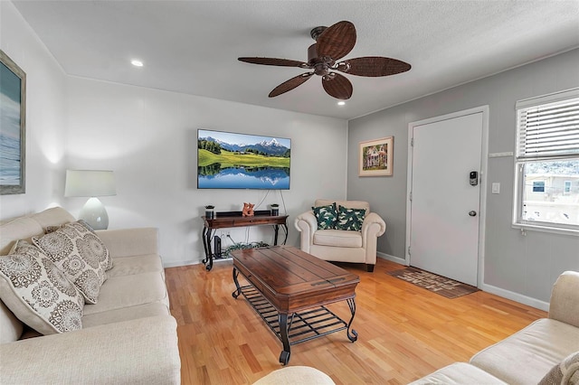 living room featuring light wood-type flooring, baseboards, a ceiling fan, and recessed lighting