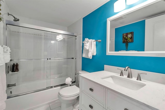 bathroom featuring toilet, shower / bath combination with glass door, and vanity