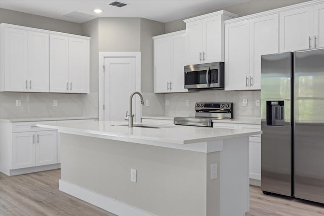 kitchen with white cabinetry, appliances with stainless steel finishes, light countertops, and a sink