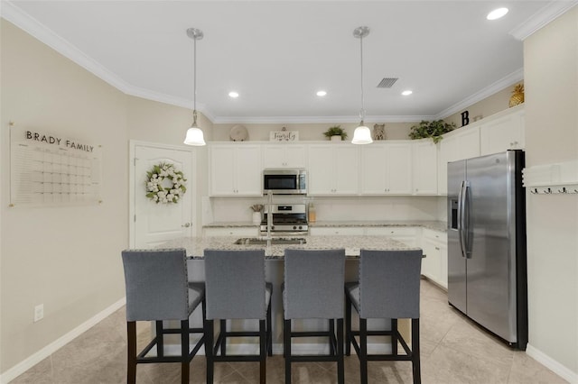 kitchen featuring visible vents, white cabinetry, hanging light fixtures, appliances with stainless steel finishes, and an island with sink