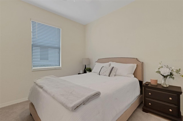 bedroom featuring light carpet and baseboards