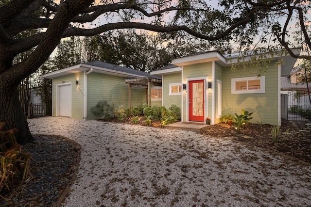 view of front of property with a garage, fence, and a pergola