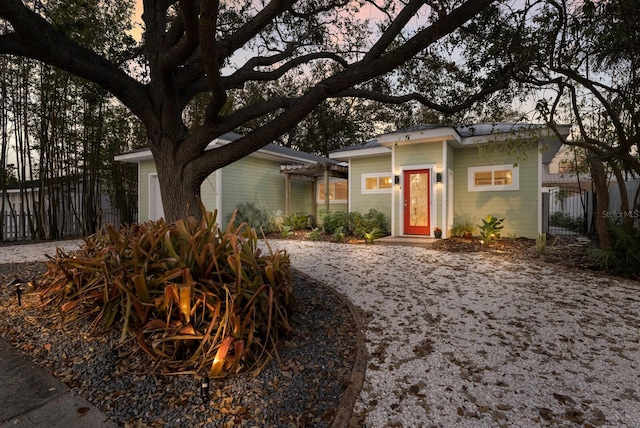 view of front of property with fence and a pergola