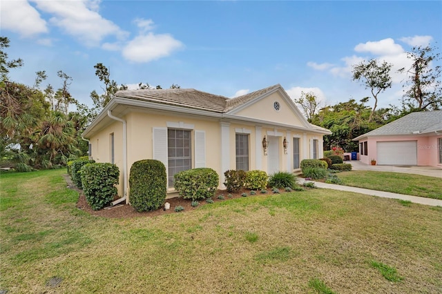 view of front facade featuring a garage, a front yard, and stucco siding