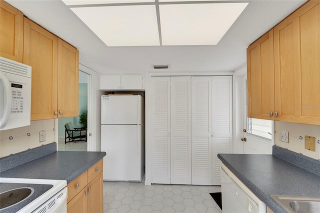 2 Antigua Cir Unit 4, Englewood, FL 34223 - kitchen with light tile patterned flooring, white appliances, a sink, visible vents, and dark countertops