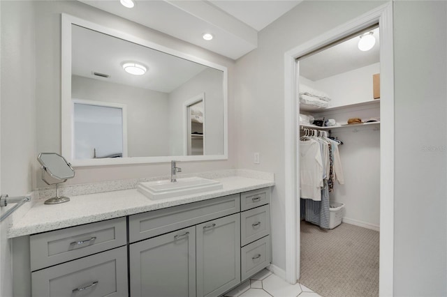 2 Antigua Cir Unit 4, Englewood, FL 34223 - bathroom featuring visible vents, a walk in closet, vanity, and baseboards