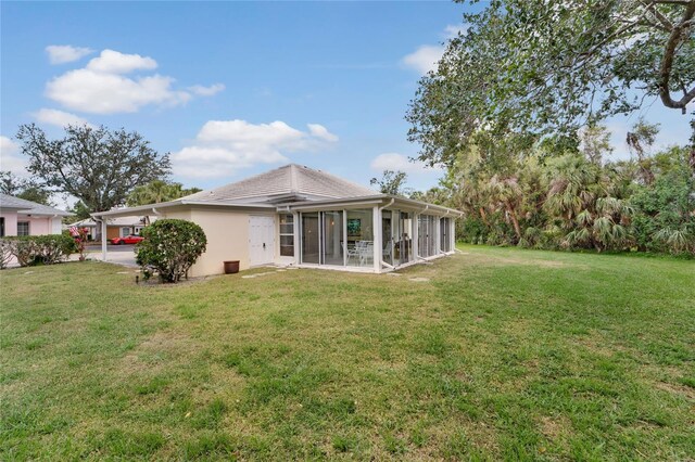 2 Antigua Cir Unit 4, Englewood, FL 34223 - back of house with an attached carport, a sunroom, a yard, and stucco siding