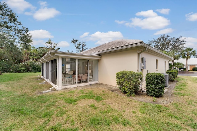 2 Antigua Cir Unit 4, Englewood, FL 34223 - back of house with a sunroom, a lawn, and stucco siding
