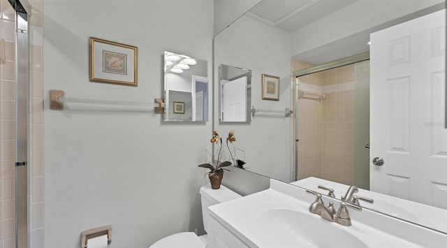 bathroom featuring toilet, a shower stall, and vanity