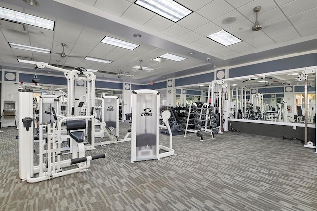 workout area with carpet flooring and a paneled ceiling