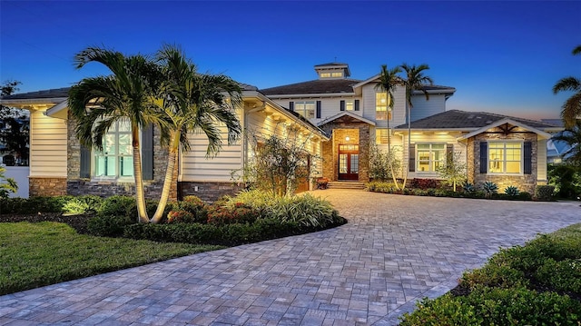 view of front of property featuring stone siding and driveway