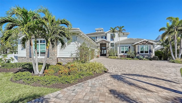 view of front of house with stone siding and decorative driveway