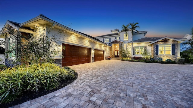 view of front of property with a garage, decorative driveway, and stone siding