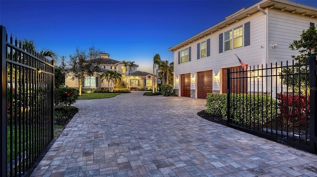 exterior space featuring a garage, decorative driveway, and fence