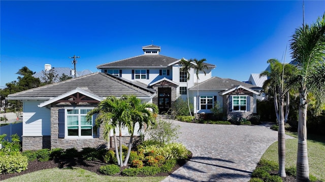 view of front facade featuring stone siding and decorative driveway