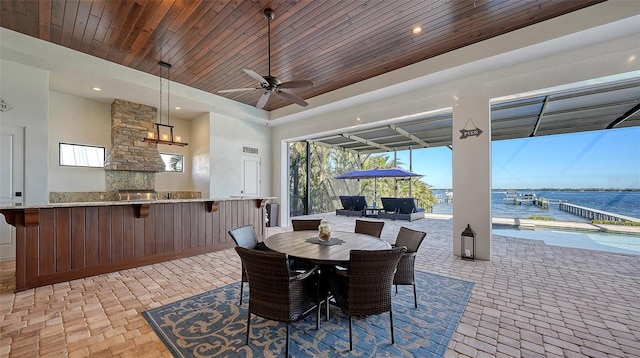 dining space with brick floor, recessed lighting, a water view, a ceiling fan, and wood ceiling