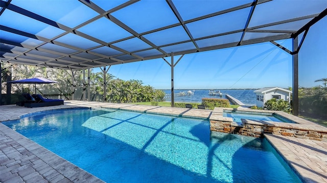 view of swimming pool featuring a pool with connected hot tub, glass enclosure, a water view, and a patio