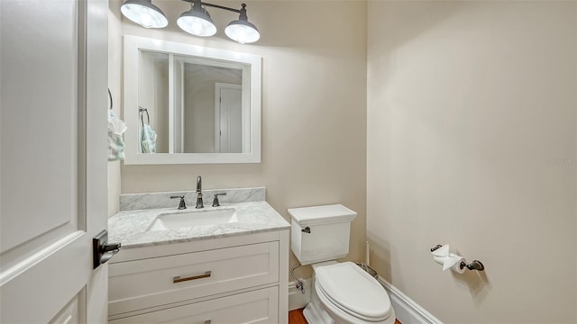 half bathroom featuring toilet and vanity