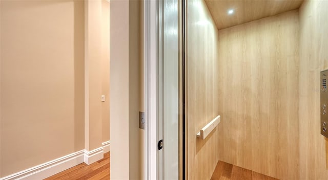 interior space with elevator, baseboards, wood finished floors, and recessed lighting