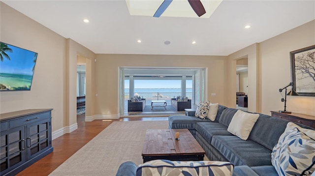 living area with a ceiling fan, baseboards, dark wood-type flooring, and recessed lighting