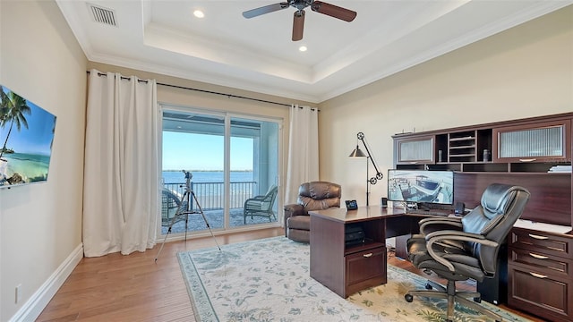 office area with a tray ceiling, ornamental molding, ceiling fan, light wood-type flooring, and baseboards