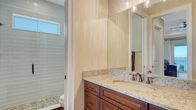 full bathroom featuring toilet, a shower stall, vanity, and a ceiling fan