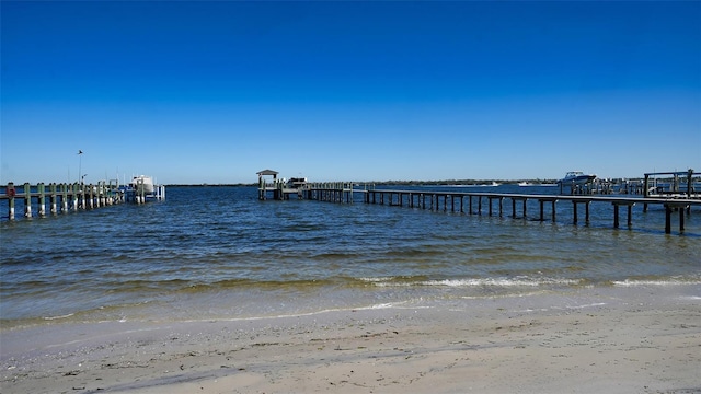 view of dock with a view of the beach and a water view