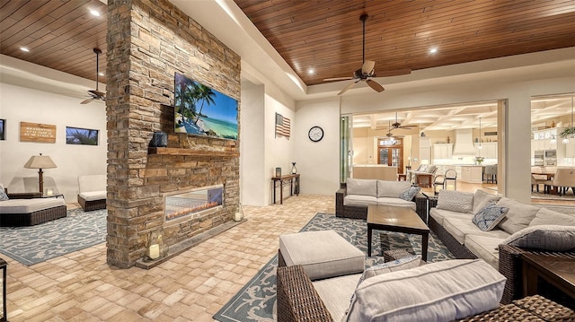 living area featuring ceiling fan, a fireplace, wood ceiling, and recessed lighting